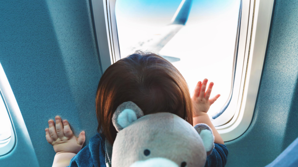 Young child looking out the window on an airplane