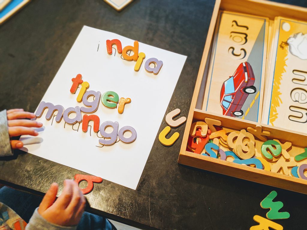Boy using wooden letters to spell words
