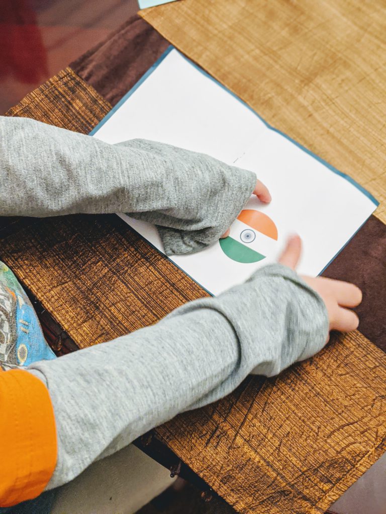 Boy putting a sticker of the Indian flag in a paper passport