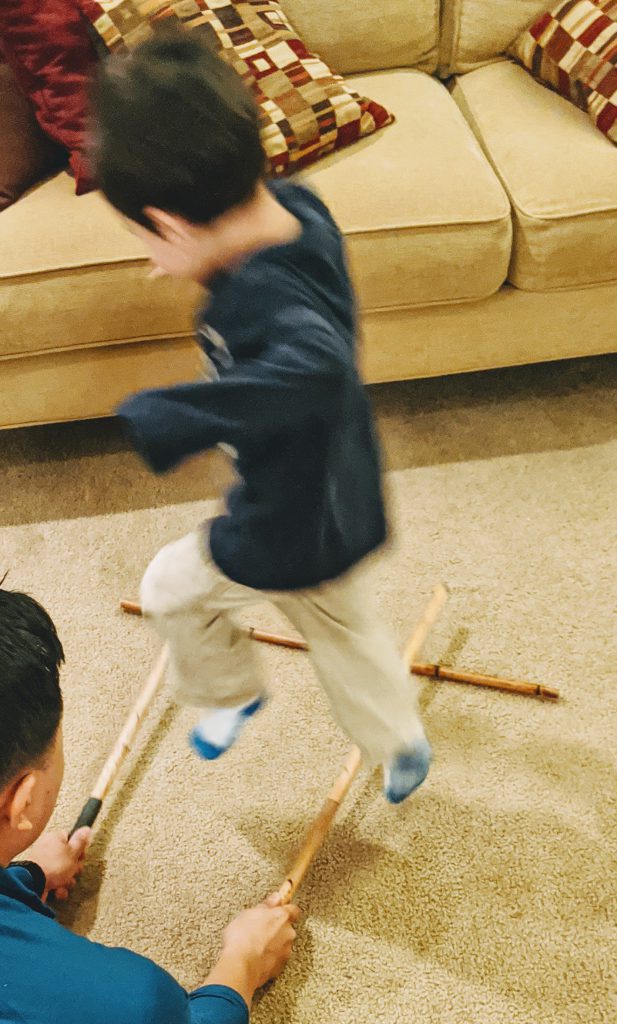 Child playing tinikling for a Philippines preschool unit