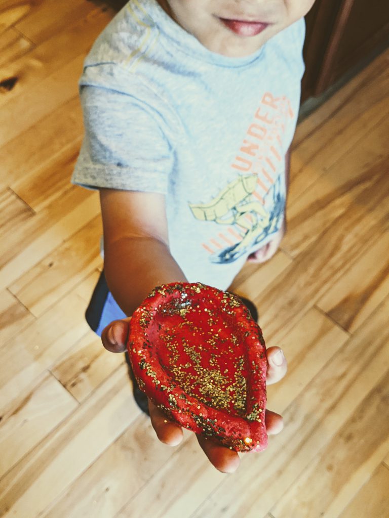 Boy holding a completed salt dough diya