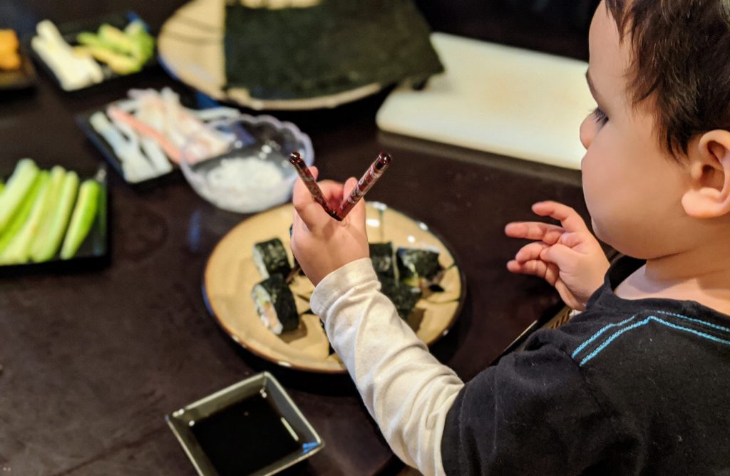 Boy eating sushi for a Japan preschool unit
