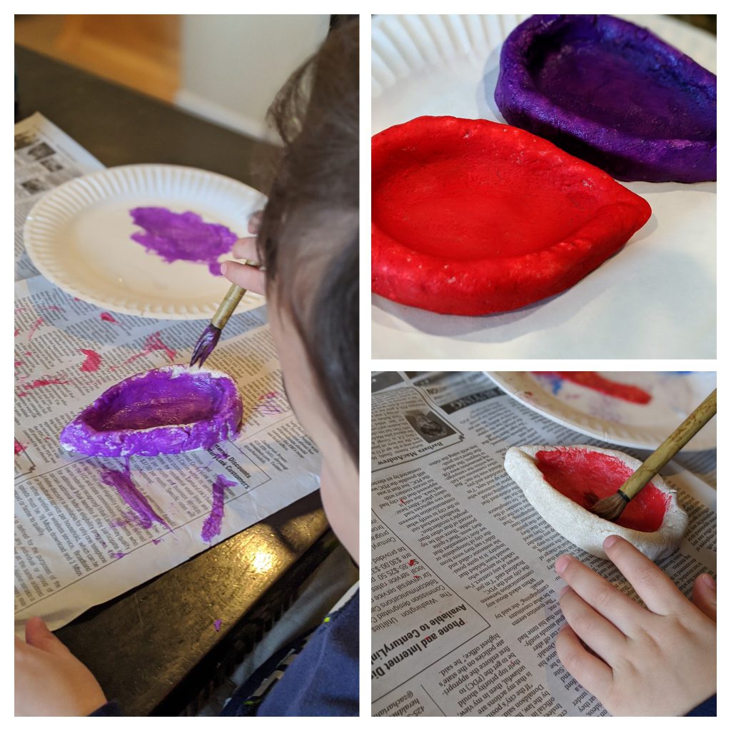 Young boy painting salt dough diyas