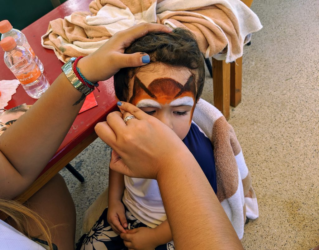 Our son getting his face painted as one of the Kidz Club activities