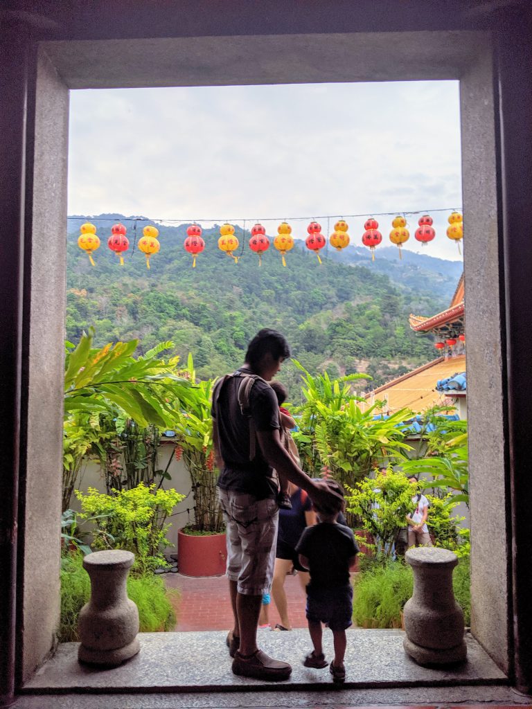 Man and two children standing in a doorway at Kek Lok Si Temple in Penang, Malaysia