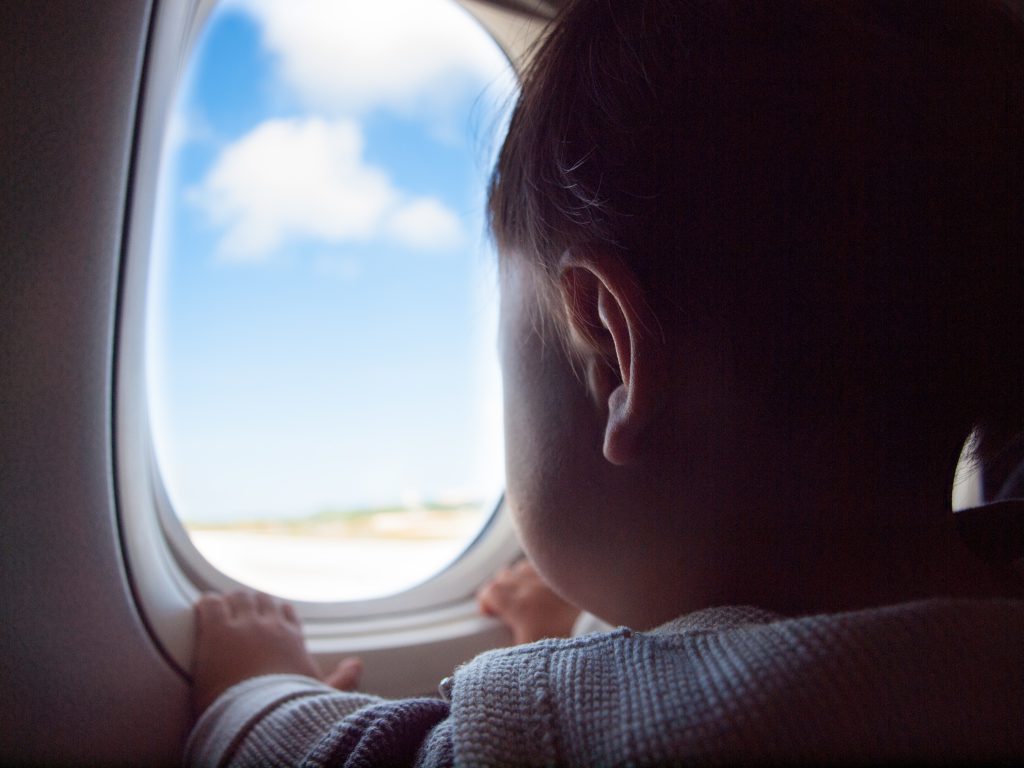 Toddler looking out a plane window