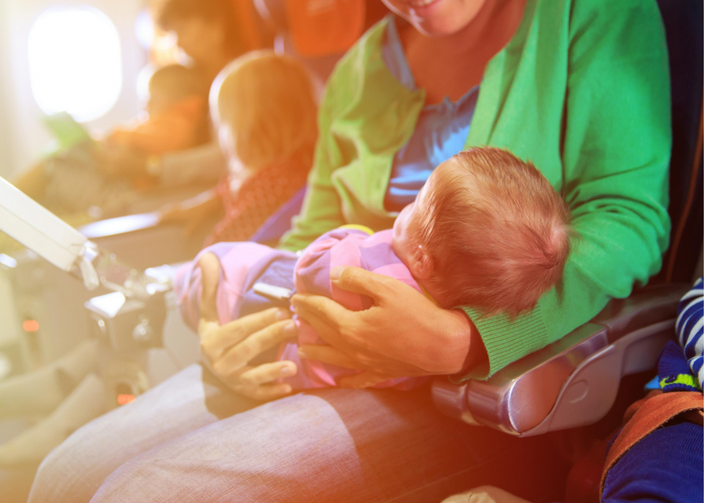 Baby sleeping on plane in parent's arms