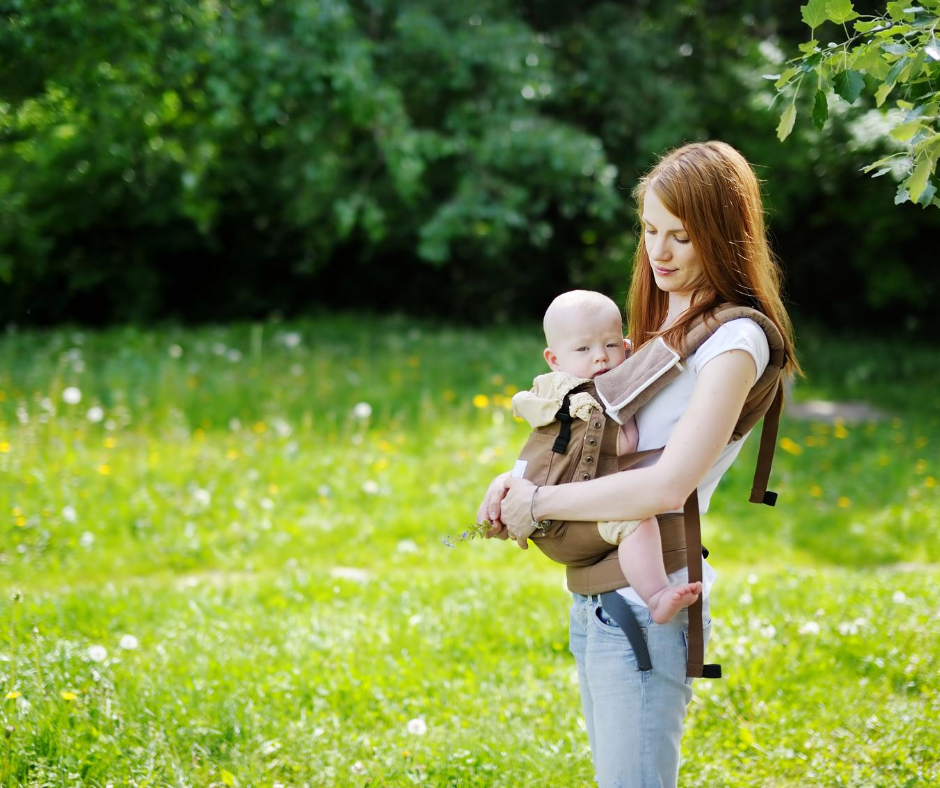 Woman wears a baby in a baby carrier