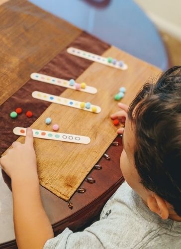 Preschool child completing the pattern sticks