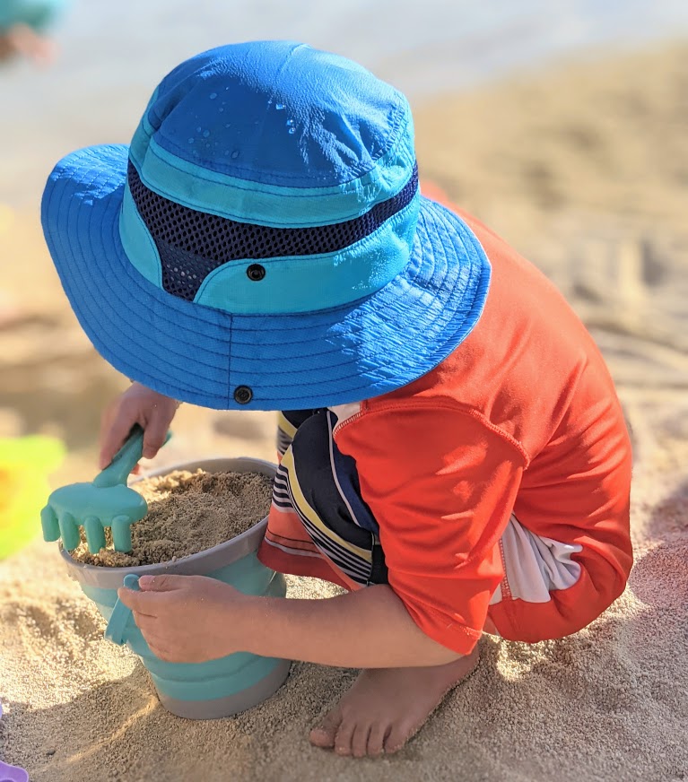 Child playing in the sand- beach essentials for toddlers and babies