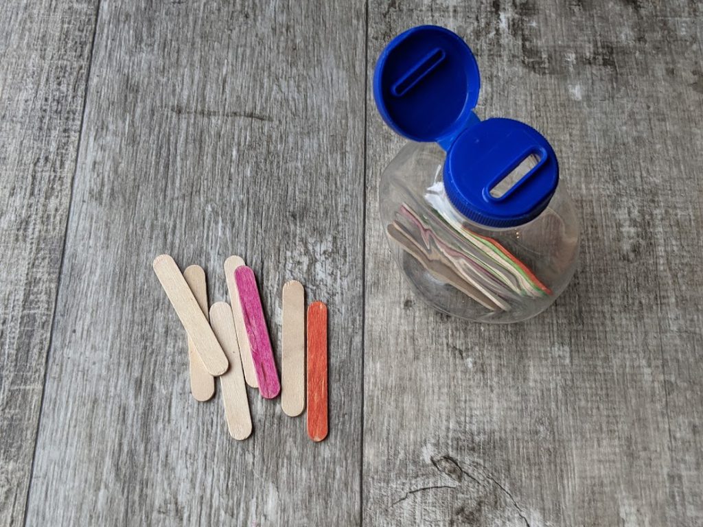Condiment container with popsicle sticks in it- toddler airplane activities