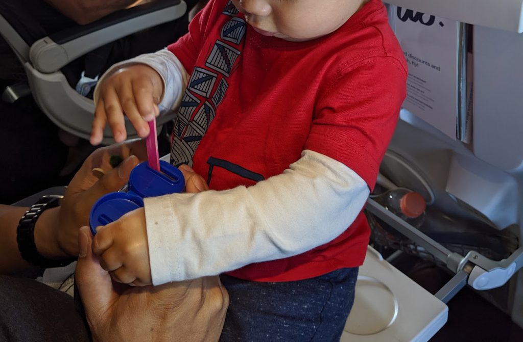 Toddler using a stick jar on a plane