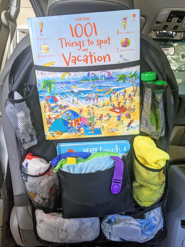 Seat back organizer in a car with kids activities in it- road trip with a toddler