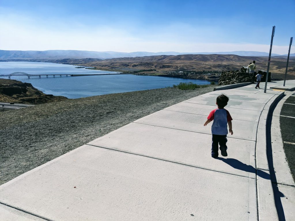 Child running on a sidewalk- road trip with a toddler