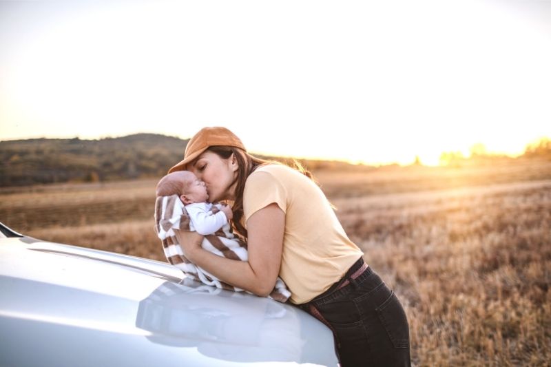 Mom and baby by car- road tripping with a baby