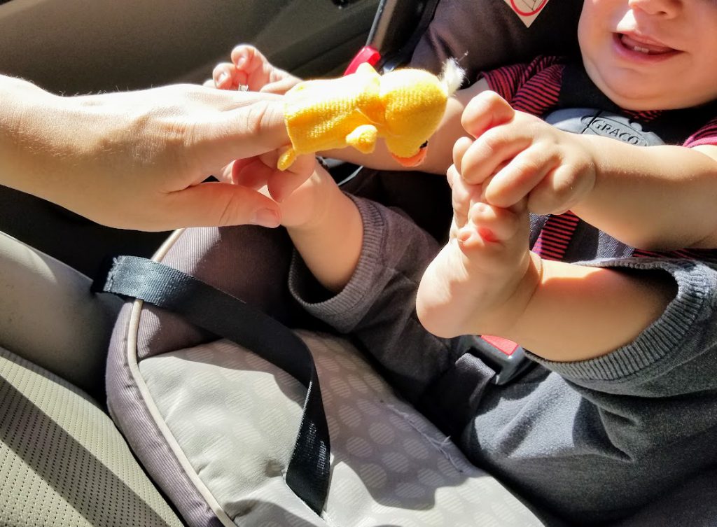 Baby smiling at a finger puppet- road tripping with a baby