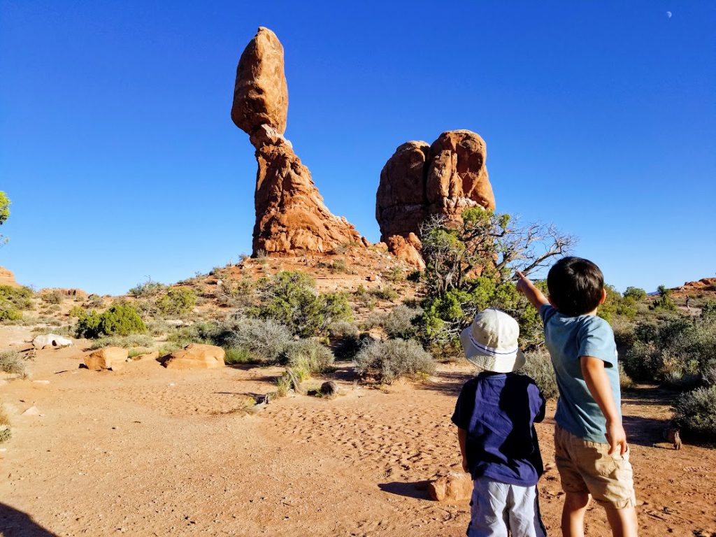 Kids looking at Balanced Rock- Arches National Park with kids