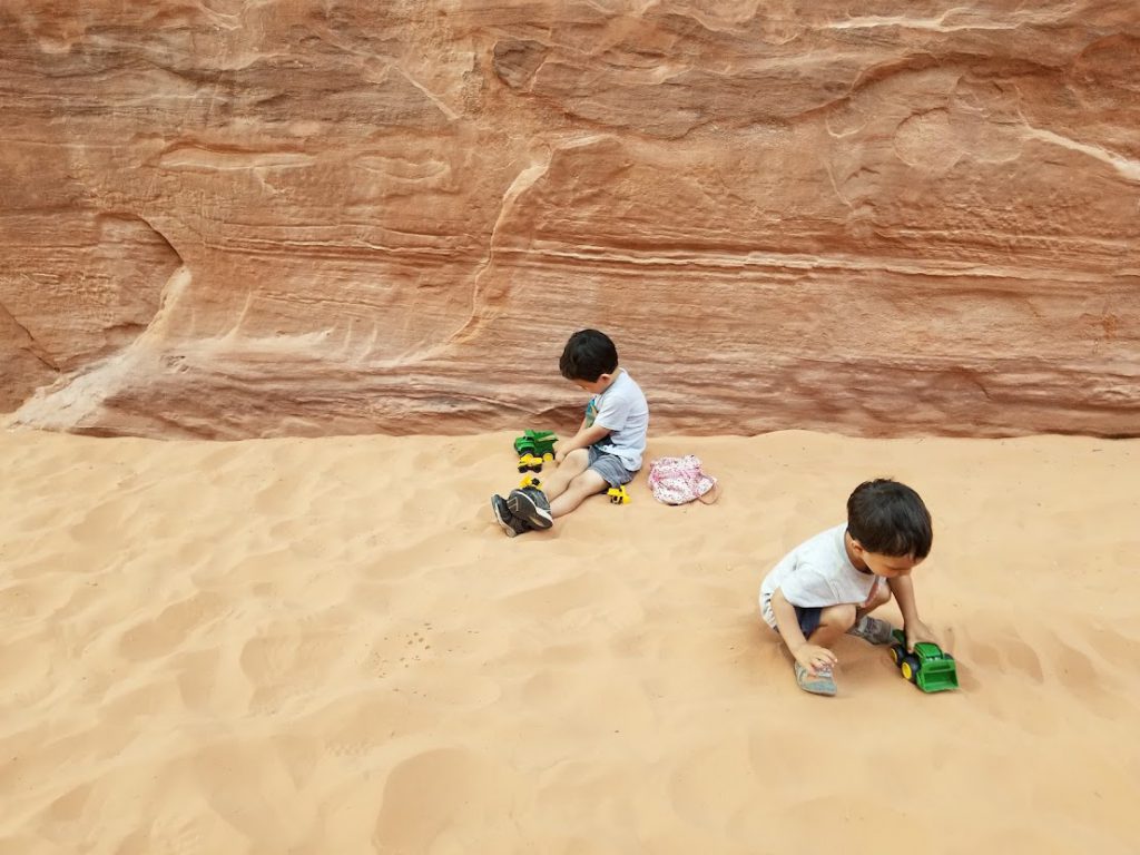 Kids playing with trucks in the sand- Arches National Park with Kids