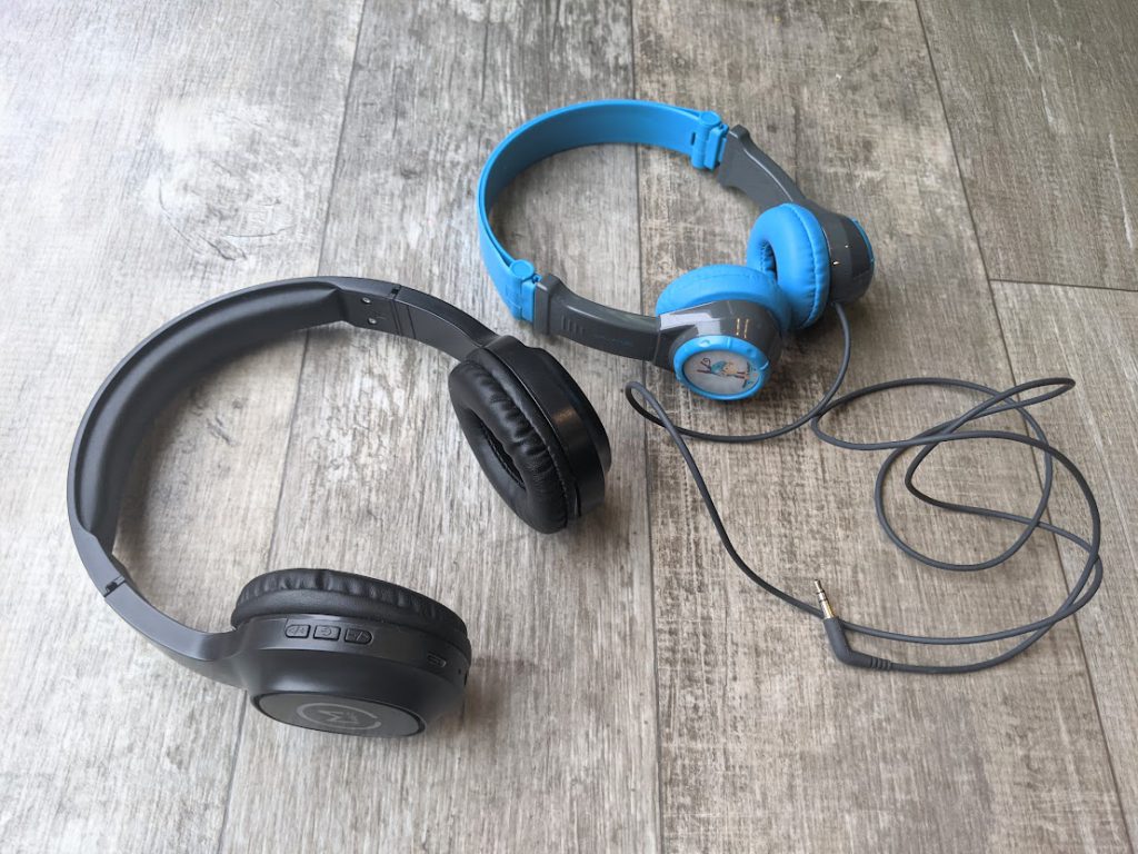 A pair of headphones with a cord and a pair of wireless headphones