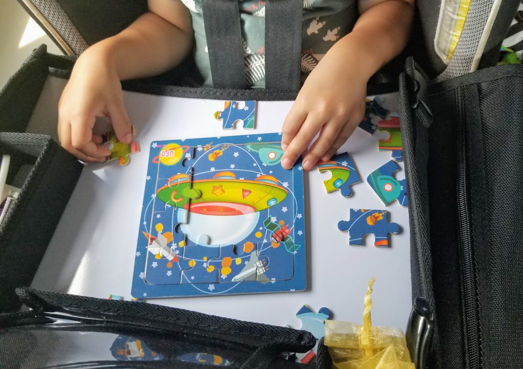 Child completing a puzzle on a road trip