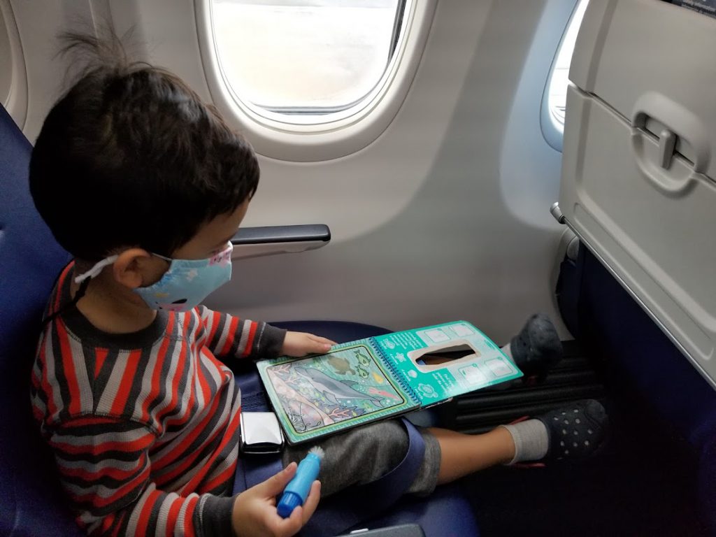 Child playing with a Water Wow! pad on a plane