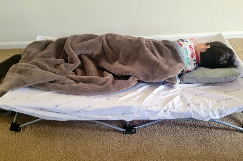 Child sleeping on a portable cot