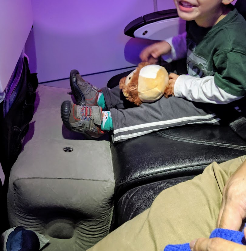Child using an inflatable footrest on an airplane