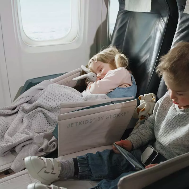 Child sleeping on a plane using the JetKids BedBox