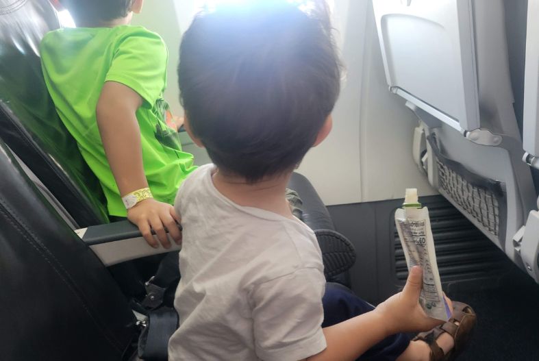 Toddler eating a fruit and veggie pouch on the plane