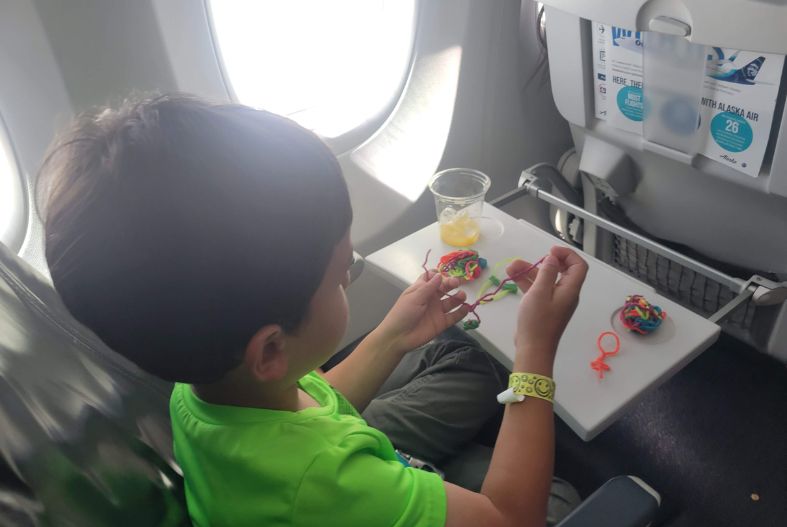 Child playing with Wikki Stix on a plane