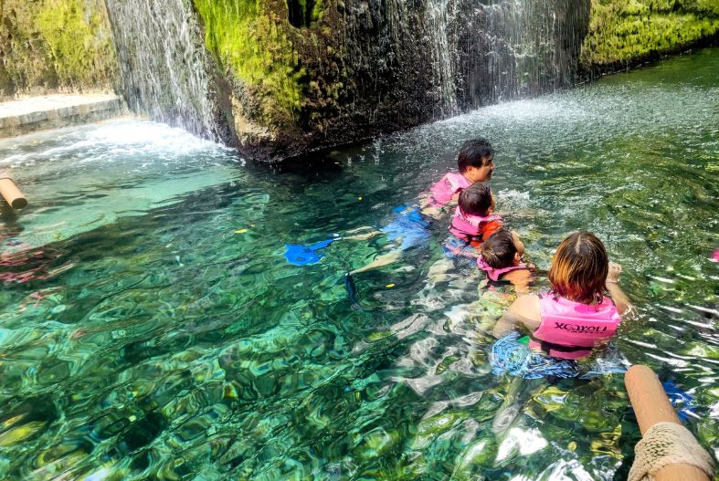 People swimming in the underground river at Xcaret