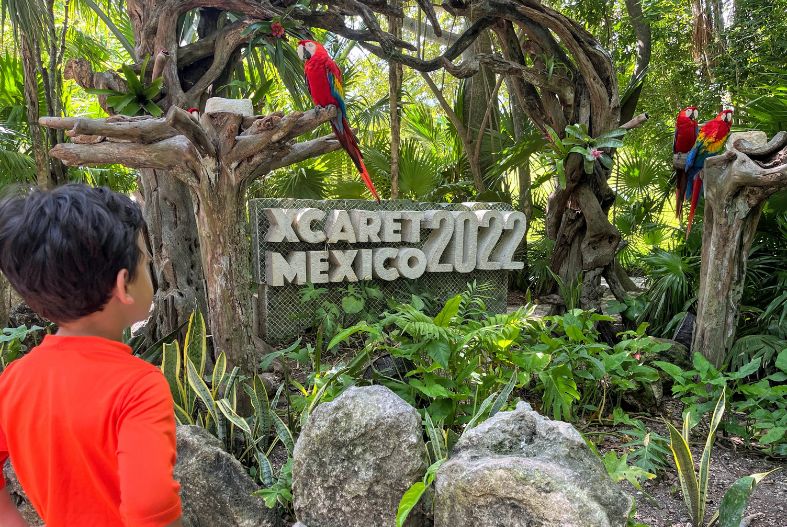 Child in front of an Xcaret Mexico sign