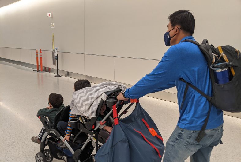 Man pushing a stroller through the airport