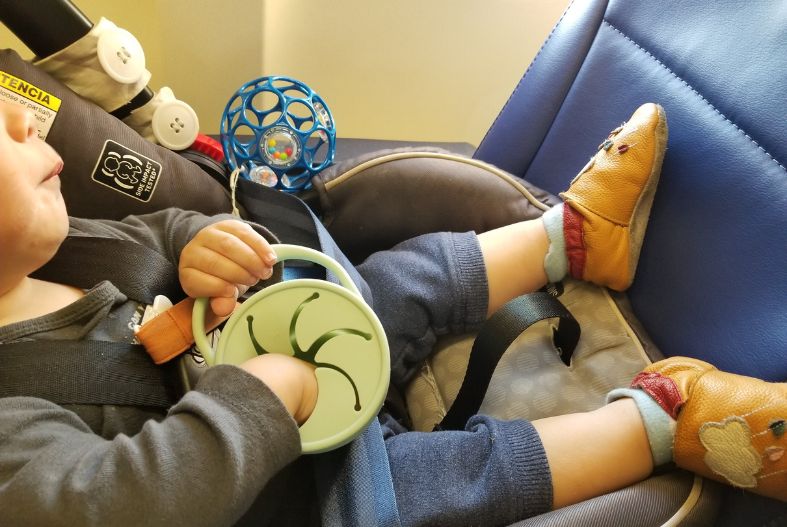 Baby eating snacks from a snack catcher on a plane- baby airplane toys