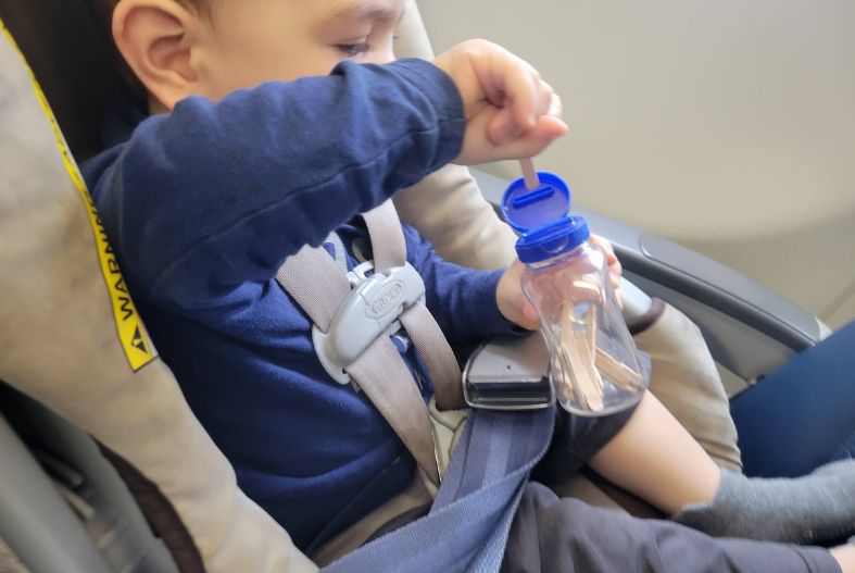 Baby playing with a stick jar on plane