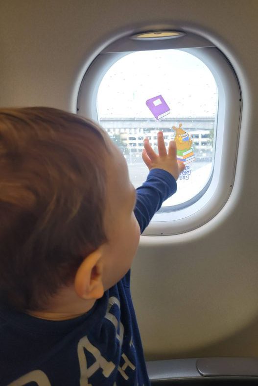 Baby with window clings on plane- airplane toys