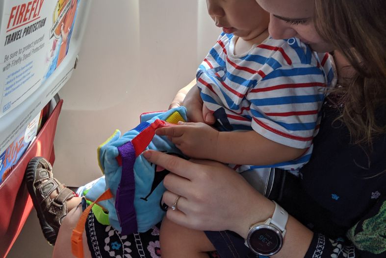 Toddler with buckle toy on plane