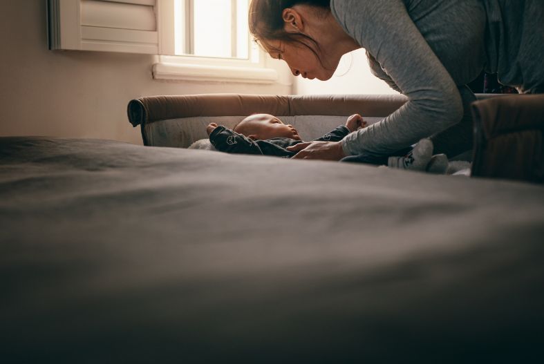 Mother with baby in baby bed