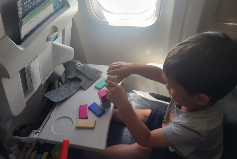 Toddler playing with Tegu Blocks on the plane