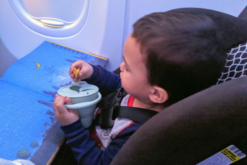 Toddler eating snack on plane