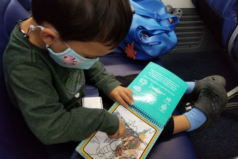 Toddler playing with a Water Wow! pad on the plane