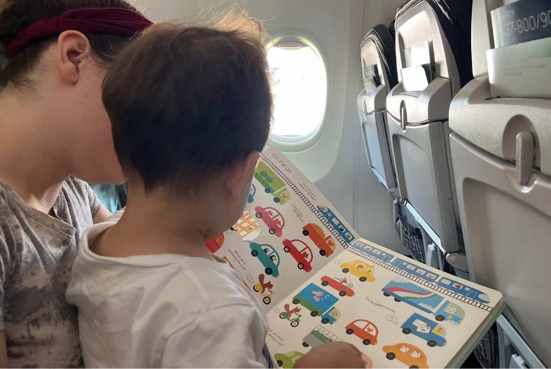 Child and mother reading a book on the plane