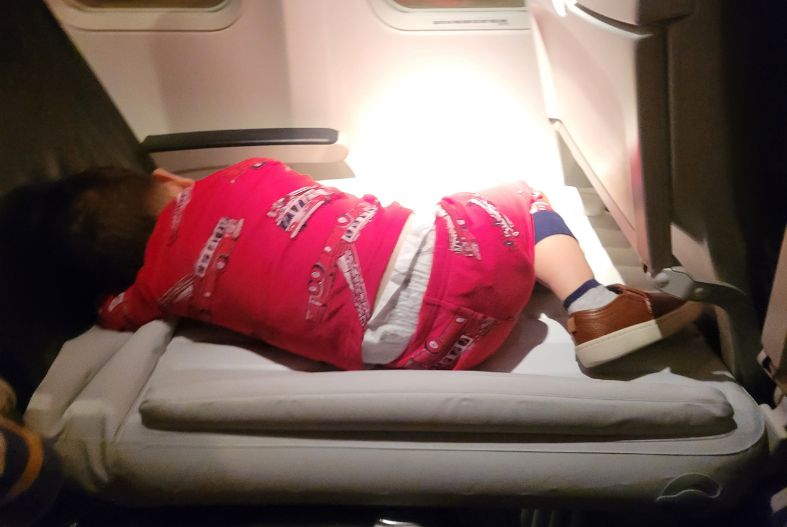 Toddler using a Flyaway Kids Bed on a plane