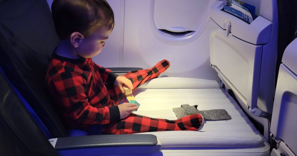 Toddler using Flyaway Kids Bed on plane