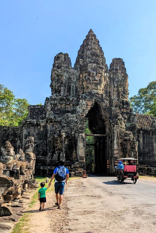 Man and child in front a gateway to Angkor Wat