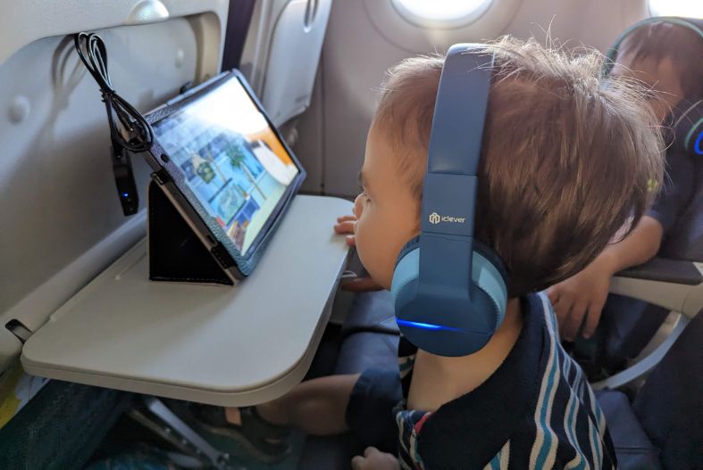 Toddler wearing headphones on a plane.