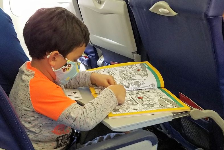 Child working on a Hidden Figures book on the plane- best ravel toys for 3 year olds