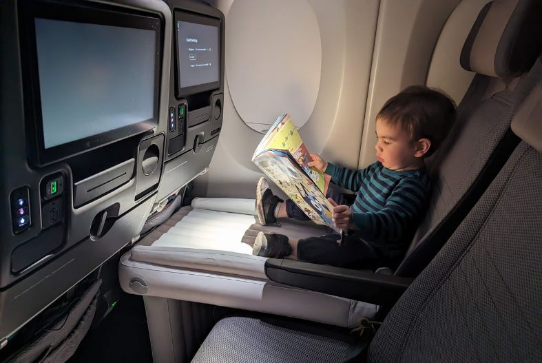 Child on an inflatable airplane bed on a plane