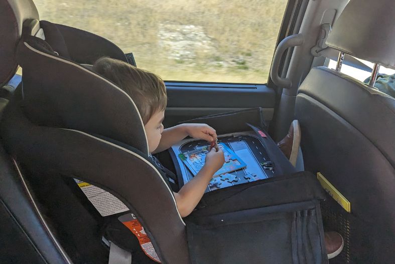 Child doing a puzzle in the car on a travel tray