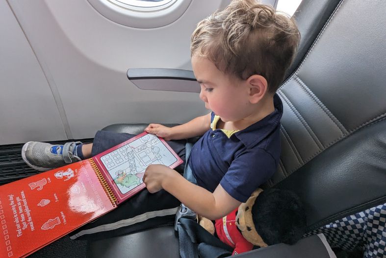 Child with WaterWow! pad on plane- best travel toys for 3 year olds